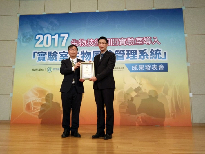 衛福部疾管署副署長莊人祥（左）頒發「楷模獎」，由國壐GTesting®檢測實驗室副理陳俊宏代表領獎